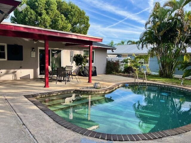 outdoor pool featuring a ceiling fan, a patio area, and fence