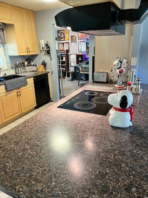 kitchen featuring dark stone counters, black dishwasher, light brown cabinets, and a textured ceiling