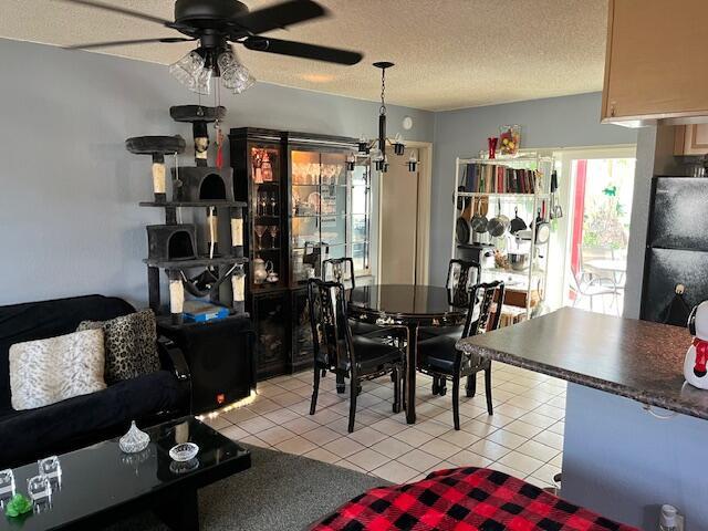 dining area featuring light tile patterned floors, a textured ceiling, and ceiling fan