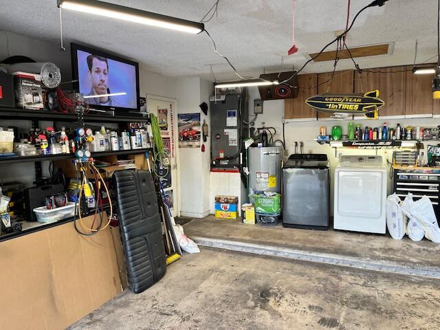 interior space with washing machine and clothes dryer, heating unit, and electric water heater