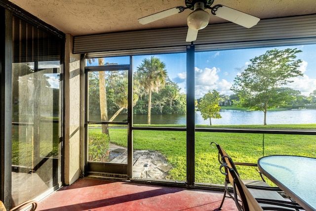 unfurnished sunroom featuring a water view, a healthy amount of sunlight, and ceiling fan