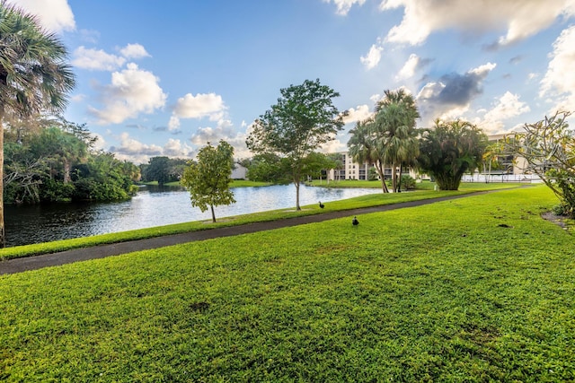 surrounding community with a lawn and a water view