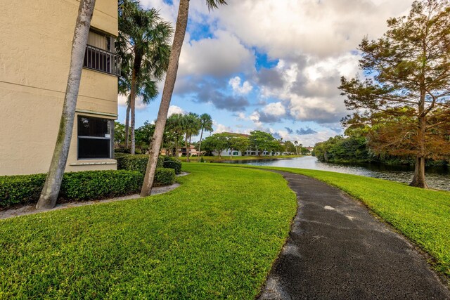 view of home's community featuring a lawn and a water view