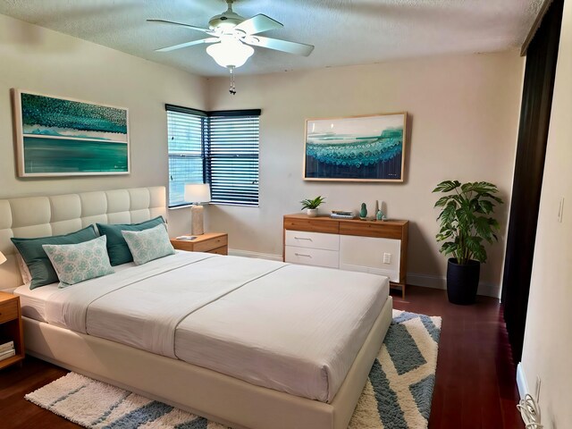 unfurnished room with a textured ceiling, dark wood-type flooring, and ceiling fan