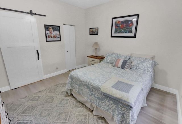 bedroom featuring light hardwood / wood-style flooring, a closet, and a barn door