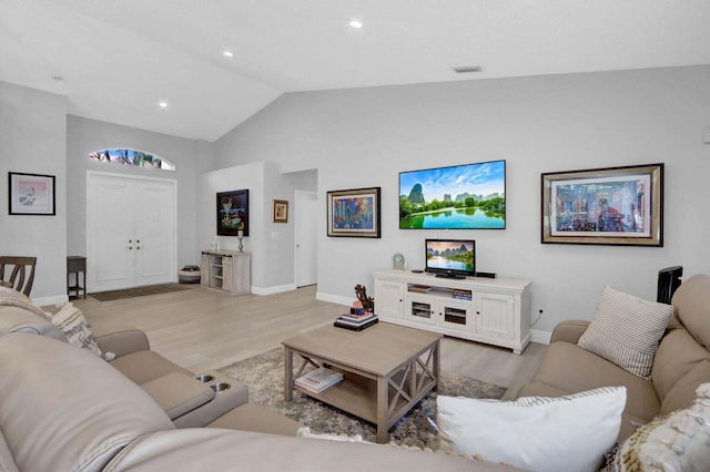 living room with light wood-type flooring and lofted ceiling