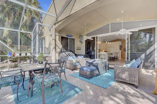 wooden terrace with an outdoor hangout area, ceiling fan, a patio area, and glass enclosure