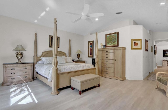 bedroom with ceiling fan, light hardwood / wood-style floors, a textured ceiling, and lofted ceiling