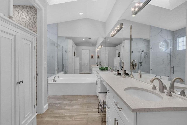 bathroom featuring vanity, vaulted ceiling with skylight, independent shower and bath, and wood-type flooring