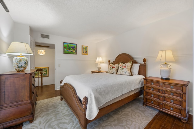 bedroom featuring hardwood / wood-style flooring and a textured ceiling