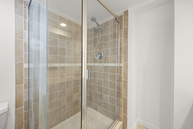 bathroom featuring an enclosed shower and toilet