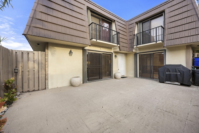 back of house featuring a balcony and a patio area