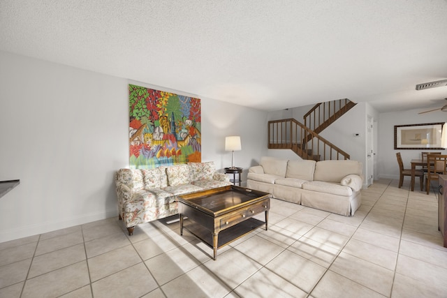 tiled living room featuring a textured ceiling