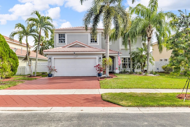 mediterranean / spanish home featuring a front yard and a garage