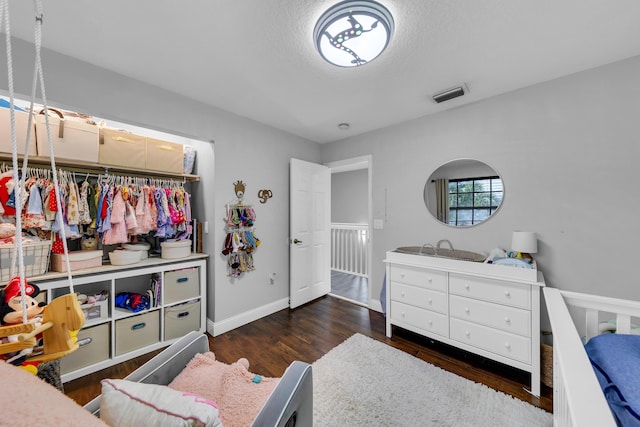 bedroom featuring a textured ceiling and dark hardwood / wood-style floors