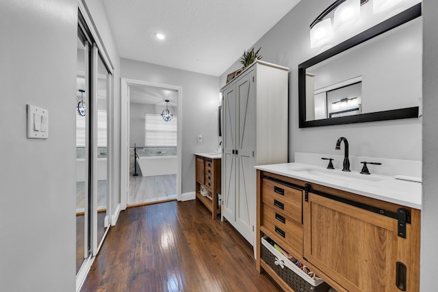 bathroom featuring vanity, a bathtub, a textured ceiling, and hardwood / wood-style flooring