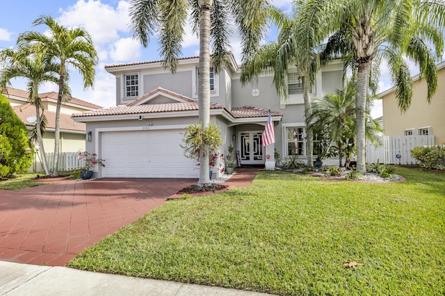 mediterranean / spanish home with a garage, a front lawn, and french doors