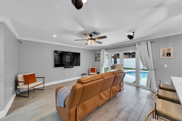 living room featuring ceiling fan, french doors, crown molding, and a textured ceiling