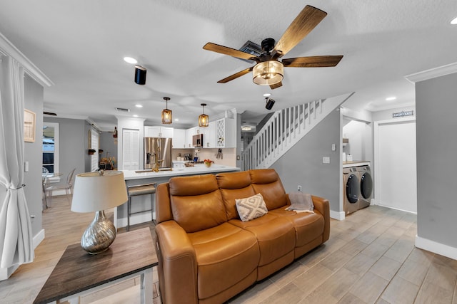 living room with ceiling fan, a textured ceiling, and crown molding