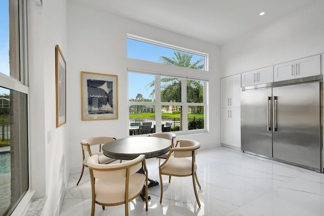 dining room with a towering ceiling and a wealth of natural light