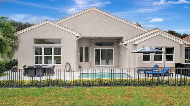 rear view of property featuring a fenced in pool, a yard, and a patio