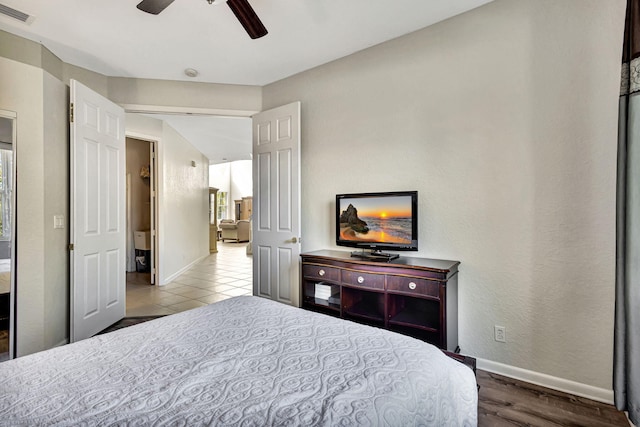 tiled bedroom featuring ceiling fan