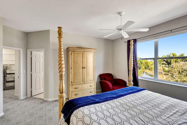 carpeted bedroom with ceiling fan and a textured ceiling