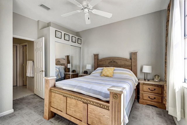 carpeted bedroom with ceiling fan and a closet