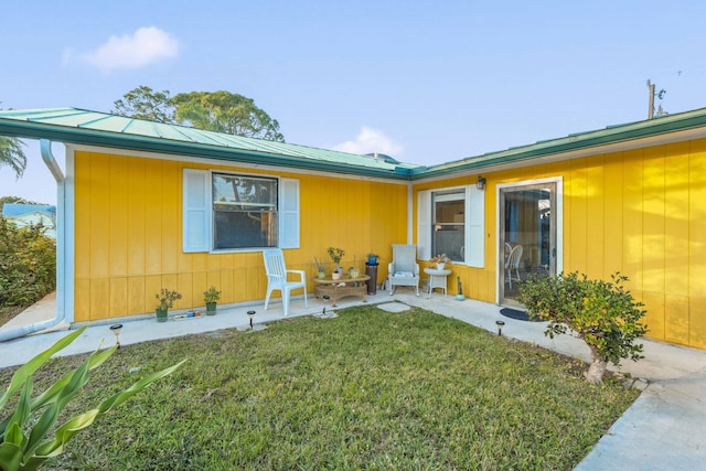 view of front of home featuring a front lawn and a patio