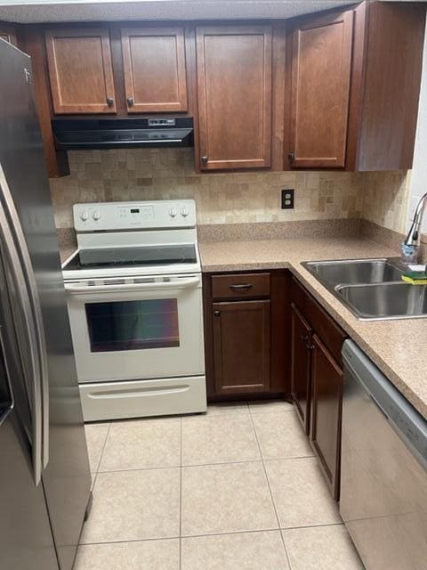 kitchen featuring light tile patterned flooring, appliances with stainless steel finishes, and sink