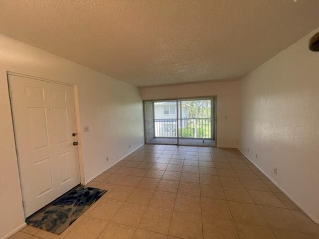 tiled spare room with a textured ceiling