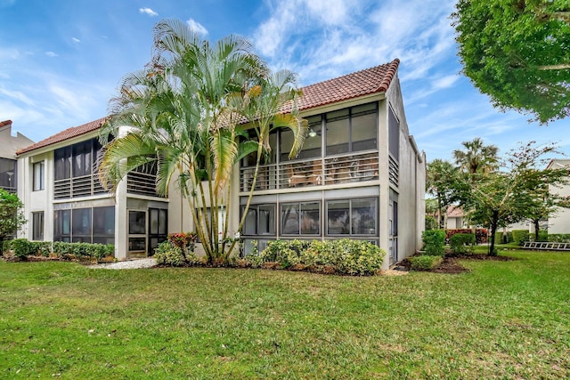 back of house with a yard and a sunroom