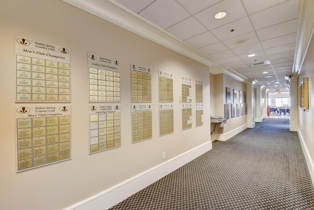 hallway featuring a paneled ceiling, ornamental molding, carpet floors, and a mail area