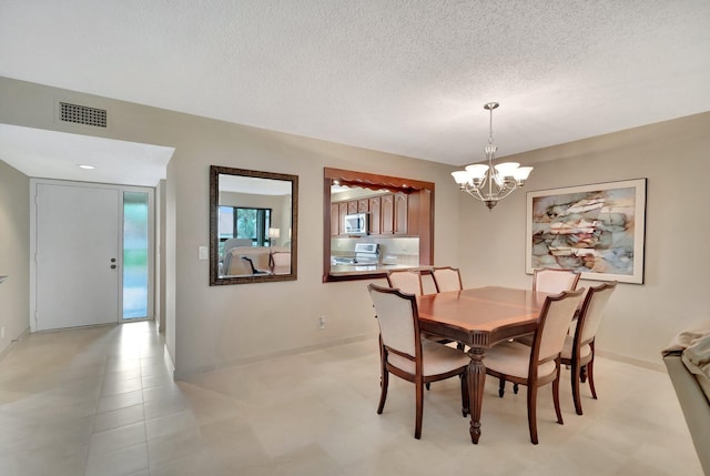 dining space featuring a textured ceiling and a chandelier