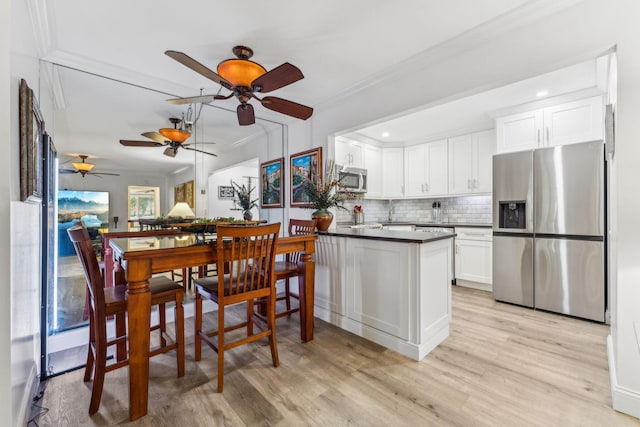 kitchen featuring kitchen peninsula, stainless steel appliances, light hardwood / wood-style floors, decorative backsplash, and white cabinets