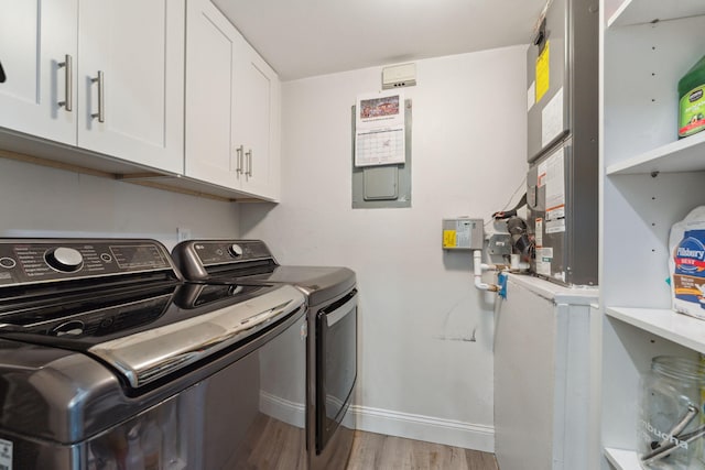 laundry area featuring cabinets, light hardwood / wood-style flooring, and independent washer and dryer