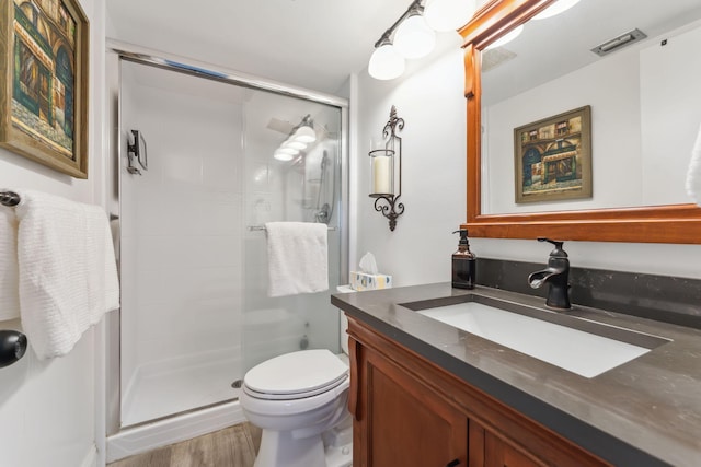 bathroom with vanity, wood-type flooring, a shower with door, and toilet