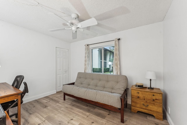 office area featuring ceiling fan, light wood-type flooring, and a textured ceiling