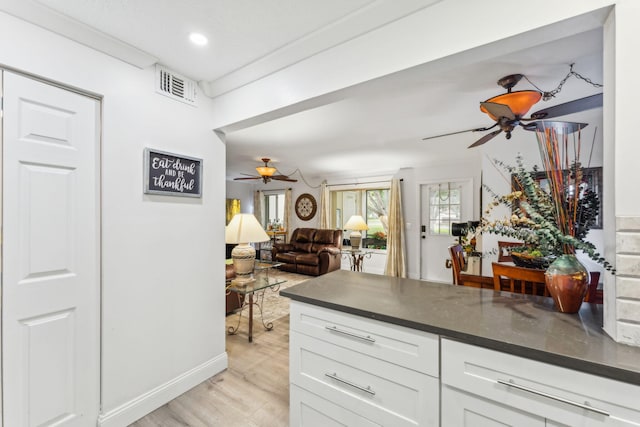 kitchen featuring white cabinetry, ceiling fan, crown molding, and light hardwood / wood-style flooring