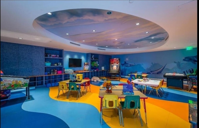 playroom with built in features and a raised ceiling