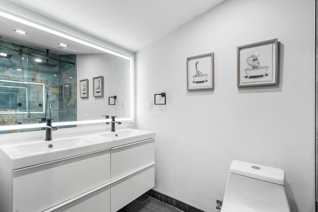 bathroom featuring tile patterned flooring, vanity, a shower with shower door, and toilet