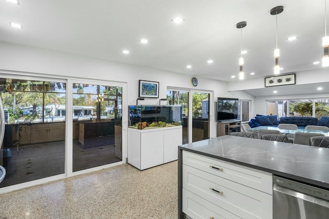 kitchen featuring white cabinetry, plenty of natural light, stainless steel dishwasher, and decorative light fixtures