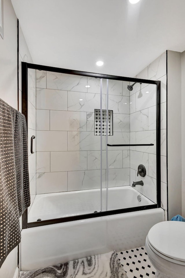 bathroom featuring toilet, tile patterned flooring, and enclosed tub / shower combo