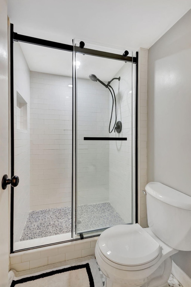 bathroom featuring an enclosed shower and toilet