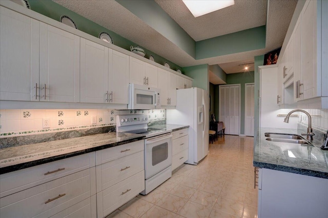 kitchen with white cabinets, white appliances, tasteful backsplash, and sink