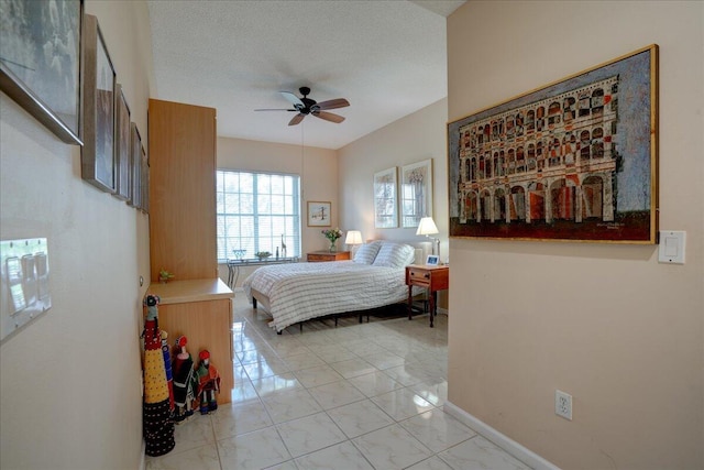 bedroom with ceiling fan and a textured ceiling