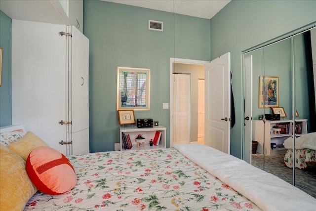 bedroom featuring a closet, a towering ceiling, and a textured ceiling