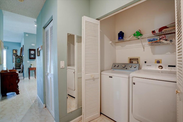 laundry area featuring a textured ceiling and washing machine and clothes dryer