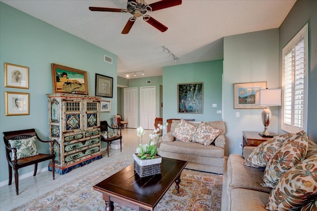 tiled living room with ceiling fan, a textured ceiling, track lighting, and a healthy amount of sunlight