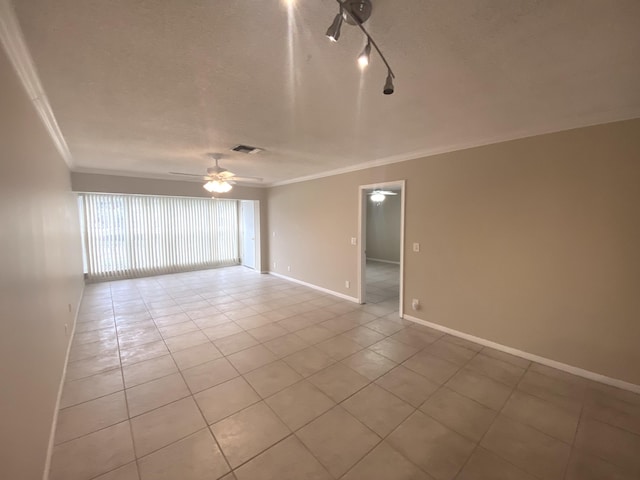 empty room with light tile patterned flooring, ceiling fan, ornamental molding, and a textured ceiling